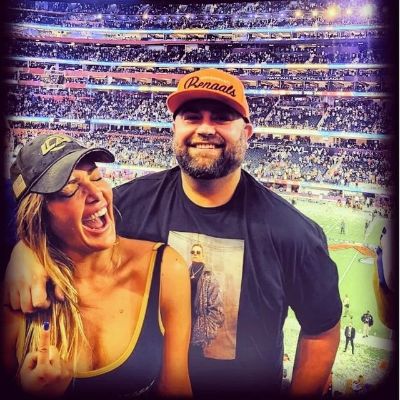 The selfie is taken at the stadium and she looks happy.